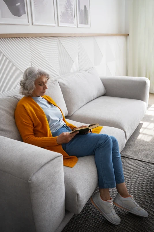 Mevrouw is aan het lezen op de bank