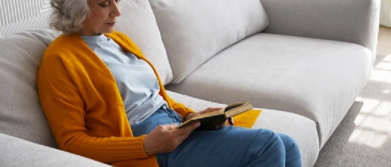 Mevrouw is aan het lezen op de bank